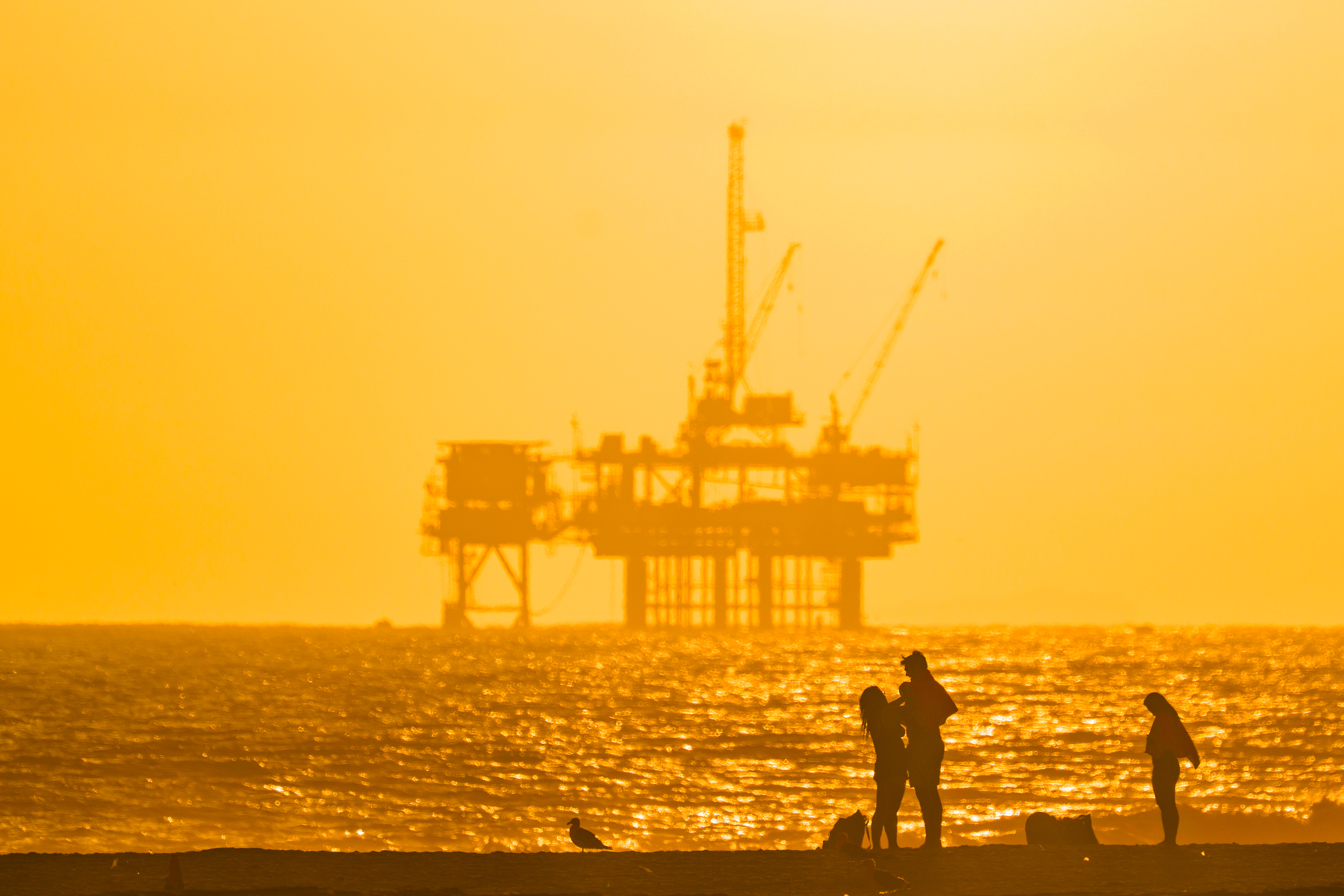 An oil platform looms in the distance off the coast of Huntington Beach, Calif., on Aug. 25. Credit: Leonard Ortiz/MediaNews Group/Orange County Register via Getty Images
