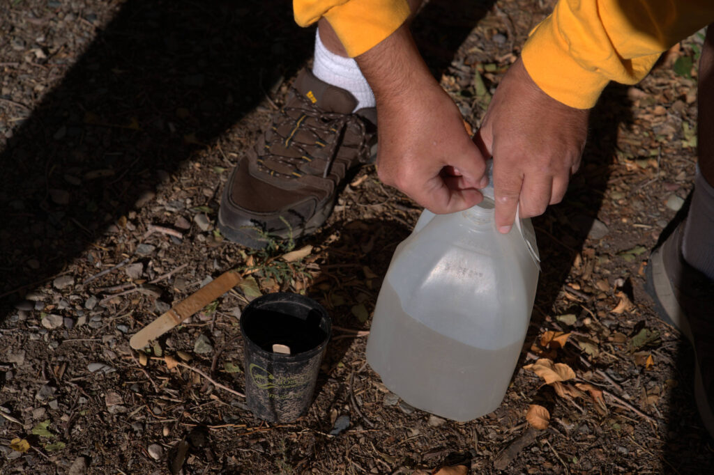 David Garrett prepares to refill a small mosquito trap with water in the Orchard Mesa neighborhood of Grand Junction, Colo.