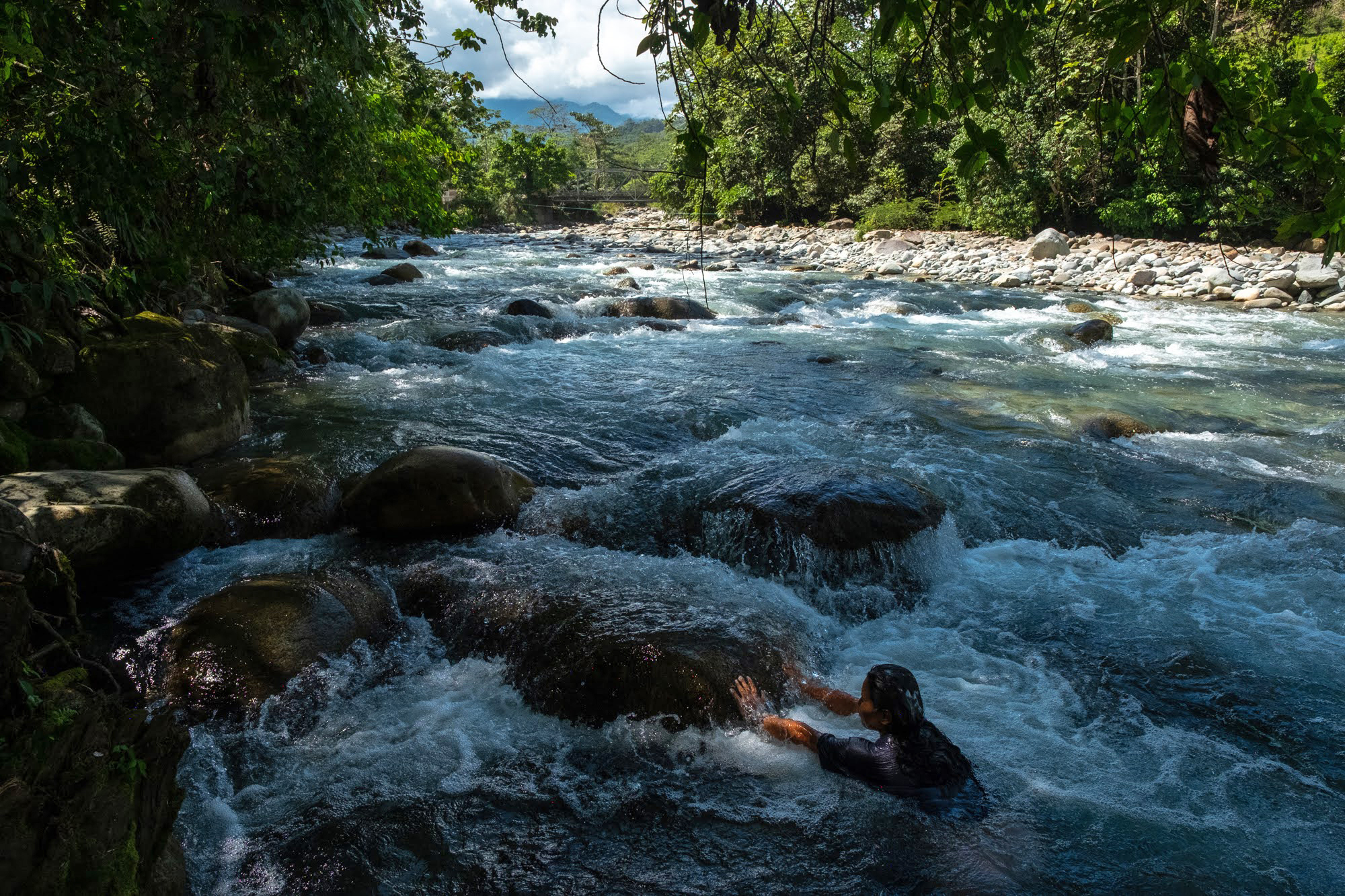 An Indigenous woman bathes in the Pepino River in Mocoa.