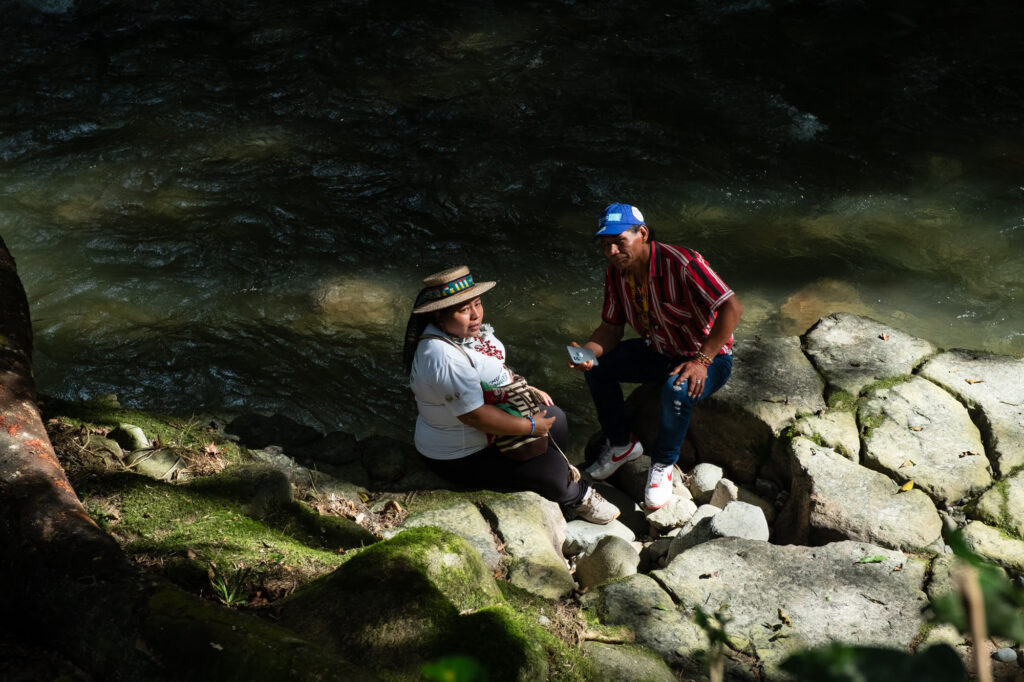 Zuly Rivera listens to Matias Redri, a Murui pueblo elder, at the Caliyacu River in Mocoa.