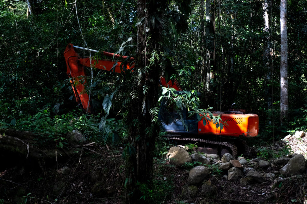 An excavator sits idle in the forest in Mocoa.
