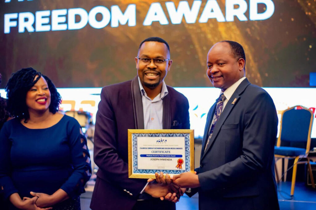 Cornelius Mweetwa, chief Zambian government spokesperson and information minister, congratulates Joseph Mwenda at the Media Institute of Southern Africa awards ceremony in September, where News Diggers won a platinum award for its documentary “Chinese Investment in Zambia–The Good, The Bad and The Dangerous.” Credit: Courtesy of Joseph Mwenda