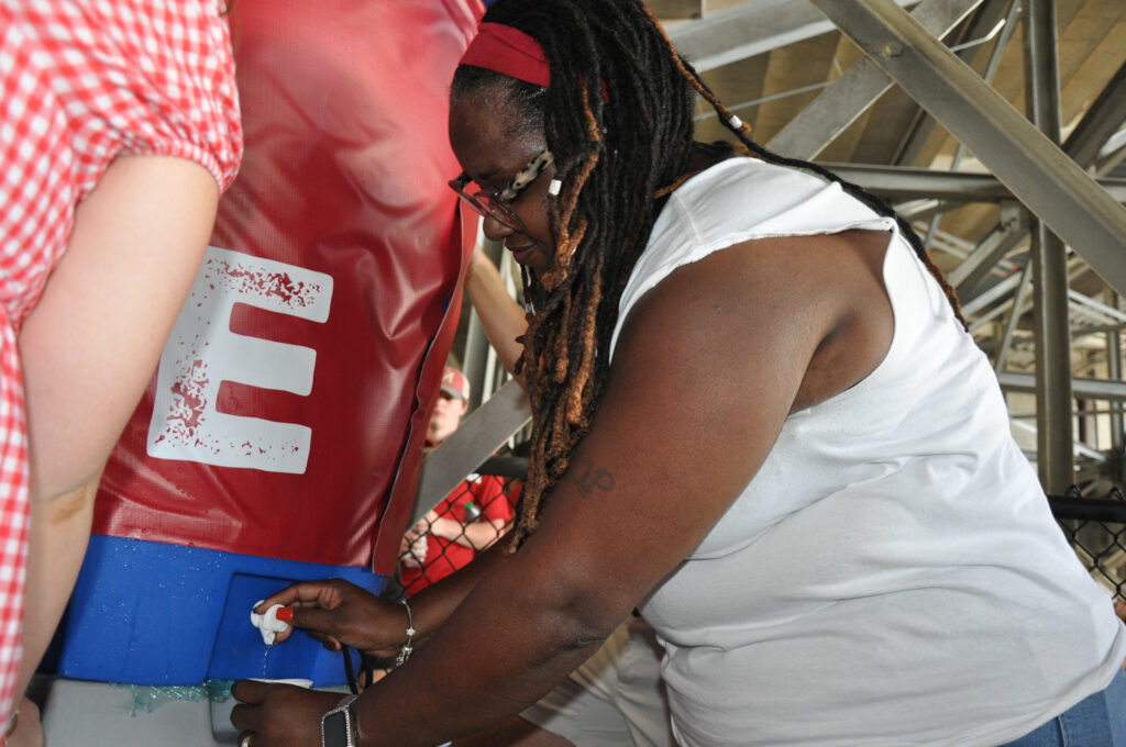 Tiffany Dunn, the aunt of a University of Alabama football player, gets water at a cooling station during the Oct. 4 Vanderbilt game at Bryant-Denny Stadium. Credit: Olivia McMurrey/Inside Climate News