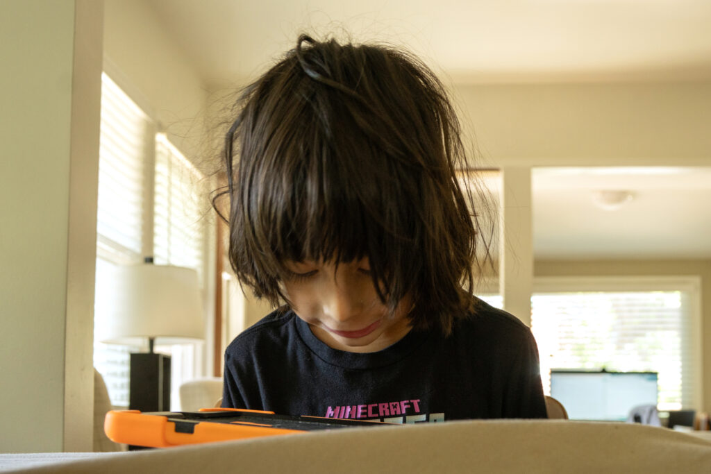 Max plays on his iPad at the family’s rental home on April 7.