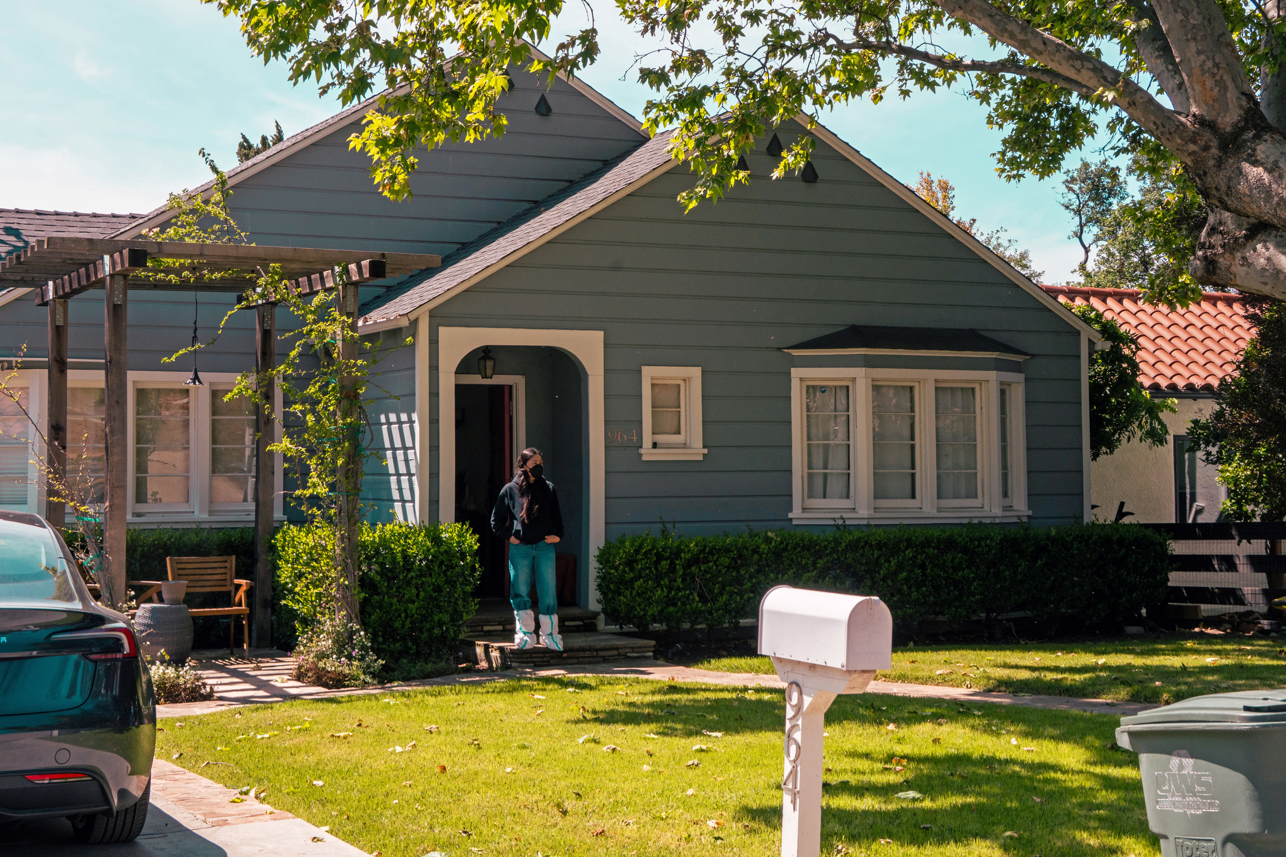 Adriana Valdez stands on the front step of her home.
