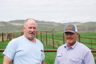 Tim Teichert and Jason Thornock, third-generation ranchers in Cokeville, Wyo., stand in Teichert’s backyard, where Thornock’s property and Rocky Mountain Power transmission lines are seen in the distance.