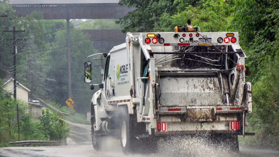 A truck for Noble Environmental, the parent company of Westmoreland Sanitary Landfill in Belle Vernon, Pa., drives down a road on a rainy day. Credit: Scott Goldsmith/Inside Climate News
