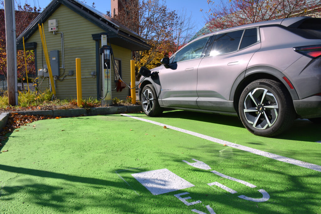 A public EV charger, powered by a small solar array, sits near the CEBE headquarters in Norway, Maine. Credit: Sydney Cromwell/Inside Climate News