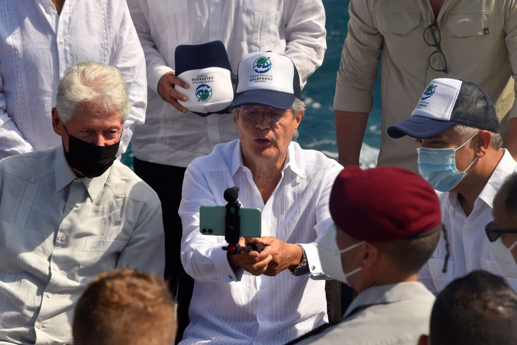 Ecuador’s President Guillermo Lasso (center) takes a selfie with former U.S. President Bill Clinton (left) and Colombia’s President Ivan Duque during the signing of a decree for expanding the Galapagos marine reserve onboard the Sierra Negra scientific vessel in the bay of Puerto Ayora off Santa Cruz Island. Credit: Rodrigo Buendia/AFP via Getty Images