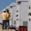 Technicians check equipment installed at a solar farm and battery storage system on Oct. 18, 2023, in Daggett, Calif. Credit: Irfan Khan/Los Angeles Times via Getty Images