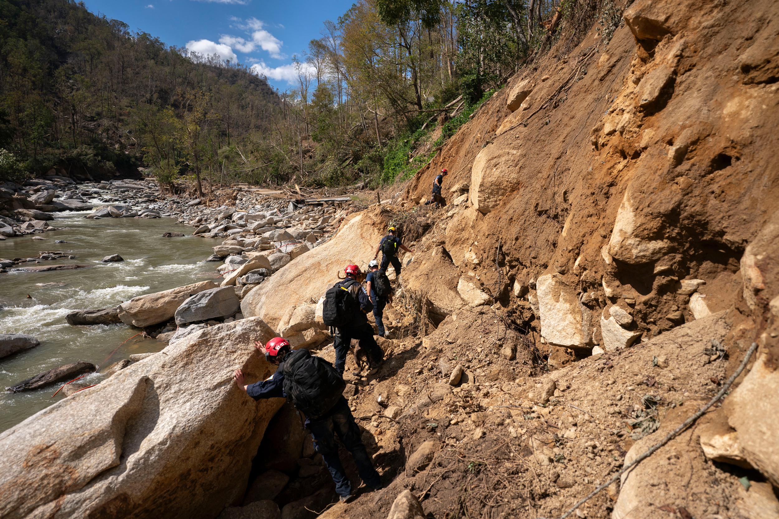 Members of a FEMA urban search and rescue team hike along the Broad River in the aftermath of Hurricane Helene on Oct. 2, 2024, near Chimney Rock, N.C. Credit: Sean Rayford/Getty Images