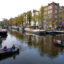 People navigate small boats through the Lekkersluis canal in Amsterdam. Credit: Nick Gammon/AFP via Getty Images