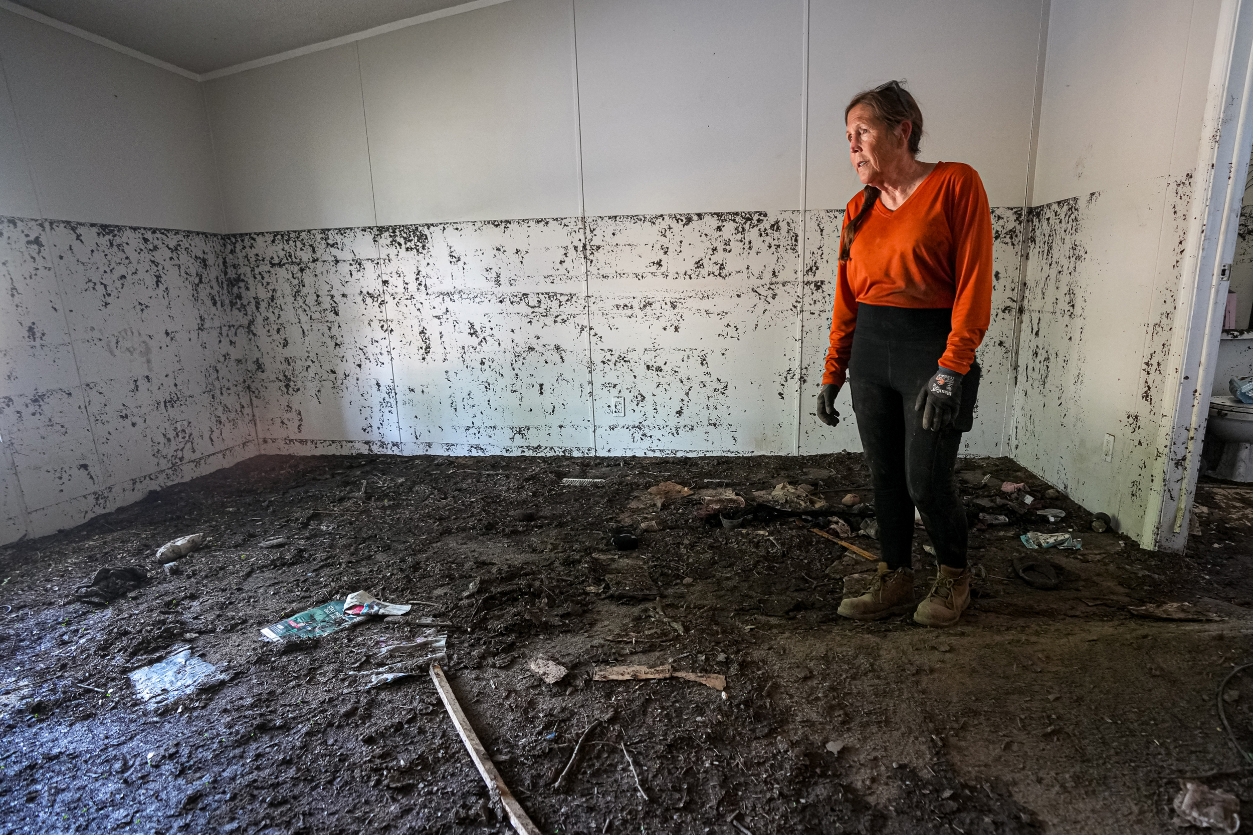 Brandy Gerstner walks through her home on July 17 in the Sandy Creek neighborhood of Leander, Texas, after heavy rain caused flash flooding in the area. Credit: Aaron E. Martinez/Austin American-Statesman via Getty Images