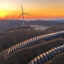 The sun sets behind wind turbines and rows of solar panels at a renewable energy farm in Qingyang, China. Credit: Chen Kun/VCG via Getty Images