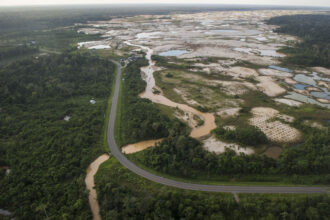 The Interoceanic Highway runs by an illegal gold mining site in La Pampa, Peru. Credit: Ernesto Benavides/AFP via Getty Images
