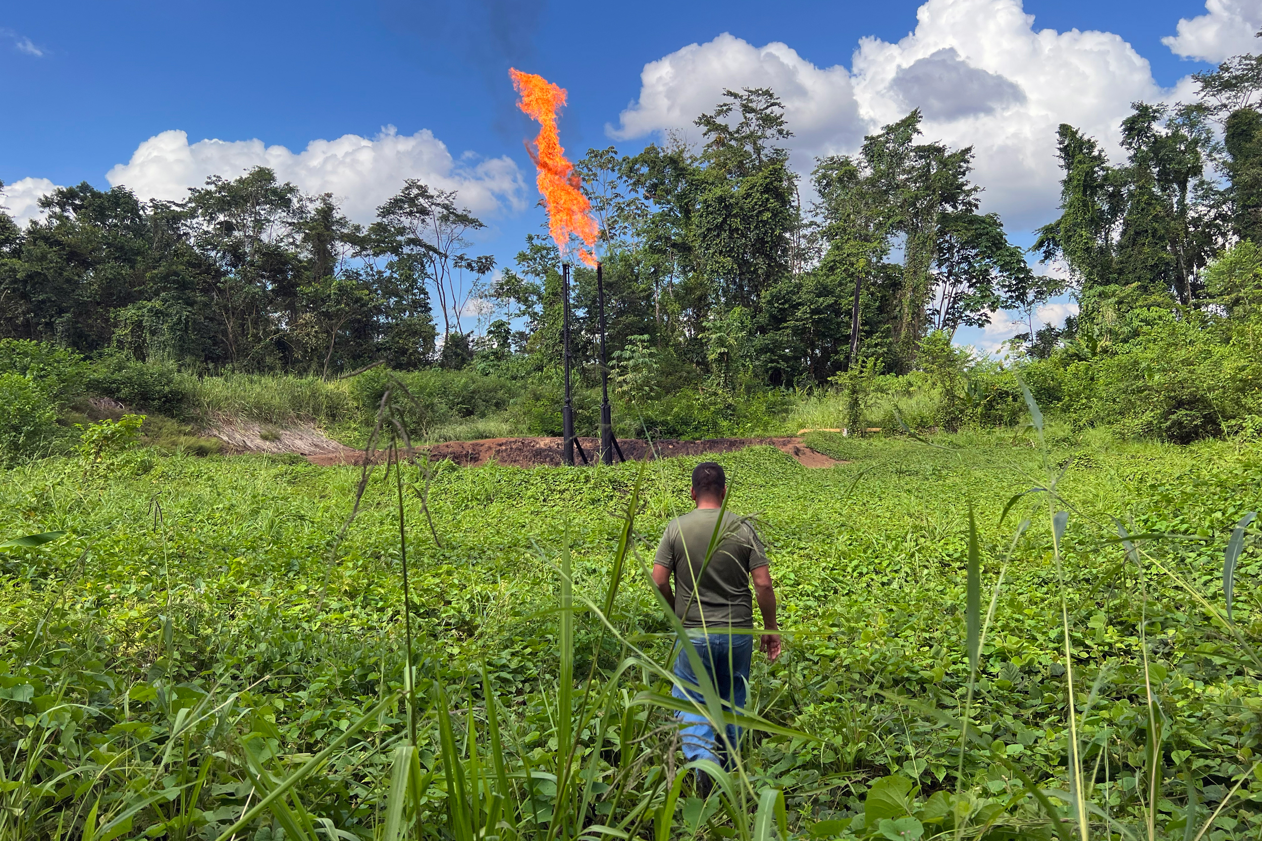 Donald Moncayo, president of the Union of Peoples Affected by Chevron-Texaco, walks toward a gas flare in the Ecuadorian Amazon region. Credit: Katie Surma/Inside Climate News