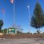 Image shows the Apex landfill exterior sign with flags above it