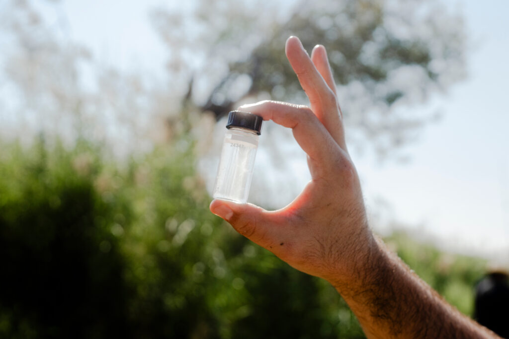 Martin Castro holds up a water sample collected from the Rio Grande in Laredo on Oct. 28.