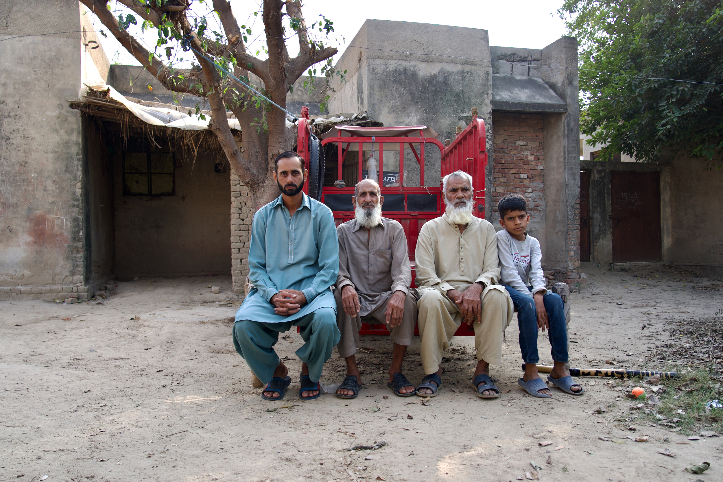 Three generations of a family in village 55/5L sit outside their home near the Sahiwal coal plant. Credit: Aman Azhar/Inside Climate News