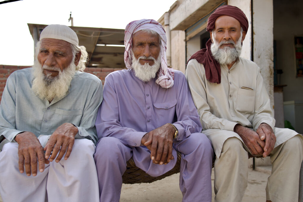 Elders from one of the settlements bordering the Sahiwal coal plant sit outside their home. They said their complaints about pollution and health issues have gone unanswered since the project began operating. Credit: Aman Azhar/Inside Climate News