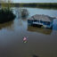 The aerial view shows a modest house and the American flag out front partially underwater.