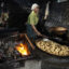 A worker fries tofu over a furnace fueled by a combination of plastic waste, wood and coconut husks at a tofu factory on May 22, 2025, in Sidoarjo, Indonesia. Credit: Robertus Pudyanto/Getty Images