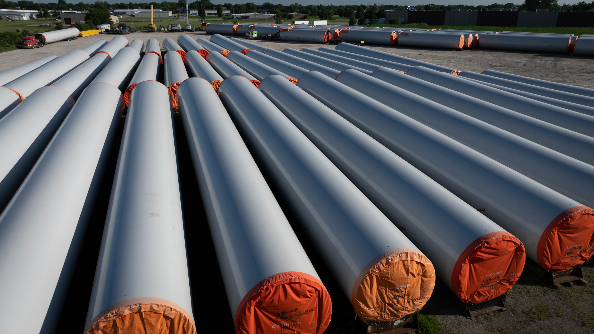 Wind tower components used in the construction of power-generating turbines sit on a lot near a manufacturing facility on July 2, 2025, in Newton, Iowa. Credit: Scott Olson/Getty Images