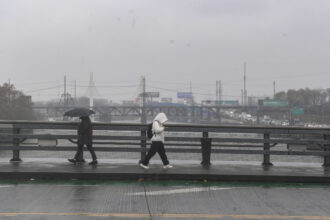 People walk through rain showers and cold temperatures in Philadelphia on Nov. 19. Credit: Matthew Hatcher/Getty Images)