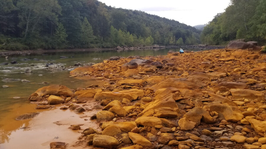 Lick Run, a tributary to West Virginia’s Cheat River, is one of many waterways in Appalachia that are impaired by pollution from coal mining. Acid mine drainage can create a reddish coloring in affected streams. Credit: Courtesy of Friends of the Cheat