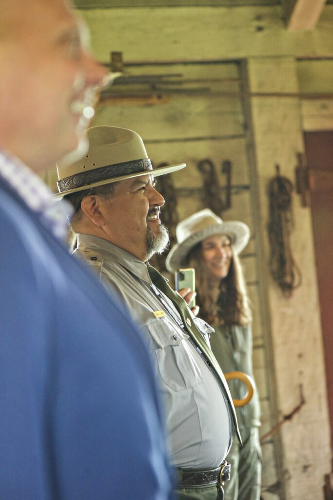Regional Director Frank Lands (left), NPS Director Charles F. "Chuck" Sams (center), and Park Ranger Sarah Weber (left) watch a demonstration at the Fort Vancouver Blacksmith Shop. Credit: National Park Service