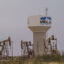 A water pipeline from the T-Bar Ranch terminates at this water tower on the western side of Midland, Texas, where oil pump jacks operate. Credit: Paul Ratje/Inside Climate News