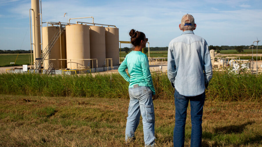 Blake Muir and his niece, Jennifer Sullivan, stand near a tank battery on his land in Gonzales County. Data shows it could come under nearly 15 feet of water in a 500-year flood. Credit: Dylan Baddour/Inside Climate News