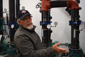 Bill Slaughter, the heating, ventilation and air conditioning technician at Colorado Mesa University, maintains the daily operations of the school’s geothermal network. Credit: Phil McKenna/Inside Climate News