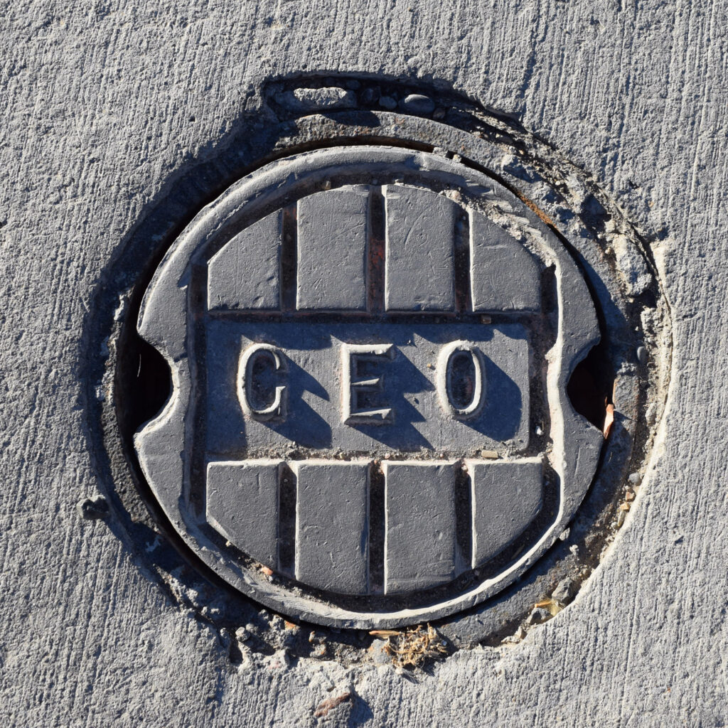The advanced geothermal heating and cooling system at Colorado Mesa University uses roughly half as much energy as a conventional heating and air conditioning system. A “Geo” valve plate cover in a parking lot indicates bore fields buried hundreds of feet below.    Credit: Phil McKenna/Inside Climate News