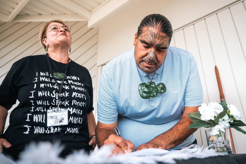 Co-chair of Hinemoana Halo Partnership Fund Lisa Tumahai and Māori leader of the Ngātiwai iwi Aperahama Edwards sign a memorandum of understanding with legal and scientific partners to advance whales’ rights on Feb. 5 in New Zealand. Credit: Courtesy of Hinemoana Halo