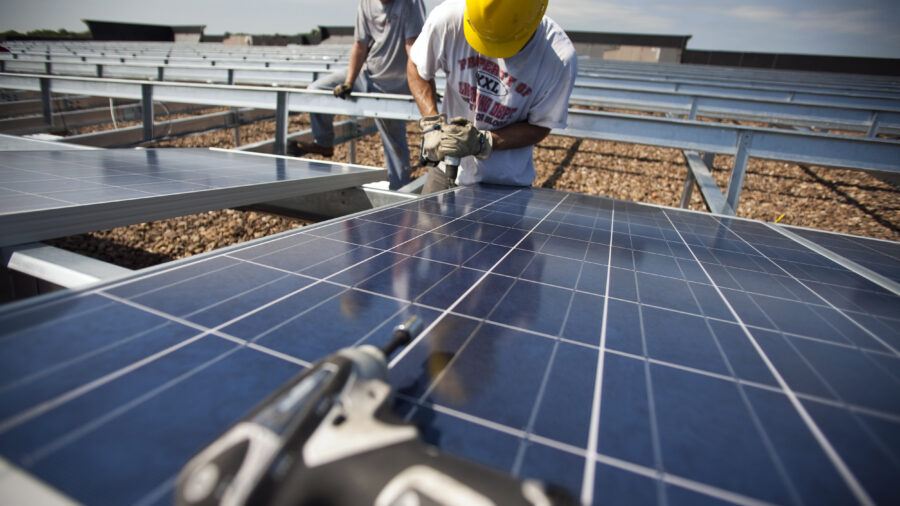 Contractors install solar panels on the roof of a department store in Hamilton Township, N.J. Credit: Robert Nickelsberg/Getty Images