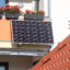 Plug-in solar panels hang from a balcony in Stralsund, Germany. Credit: Stefan Sauer/picture alliance via Getty Images