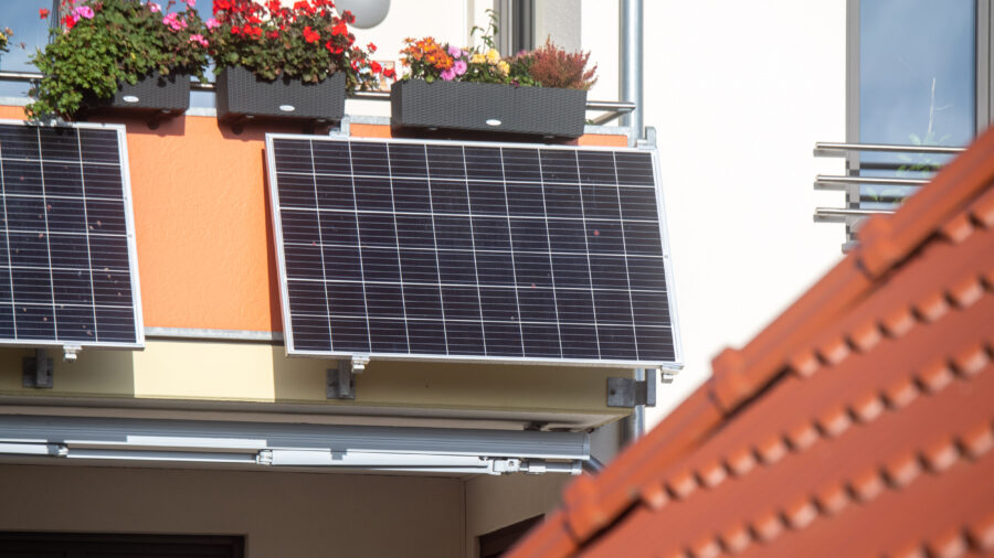 Plug-in solar panels hang from a balcony in Stralsund, Germany. Credit: Stefan Sauer/picture alliance via Getty Images