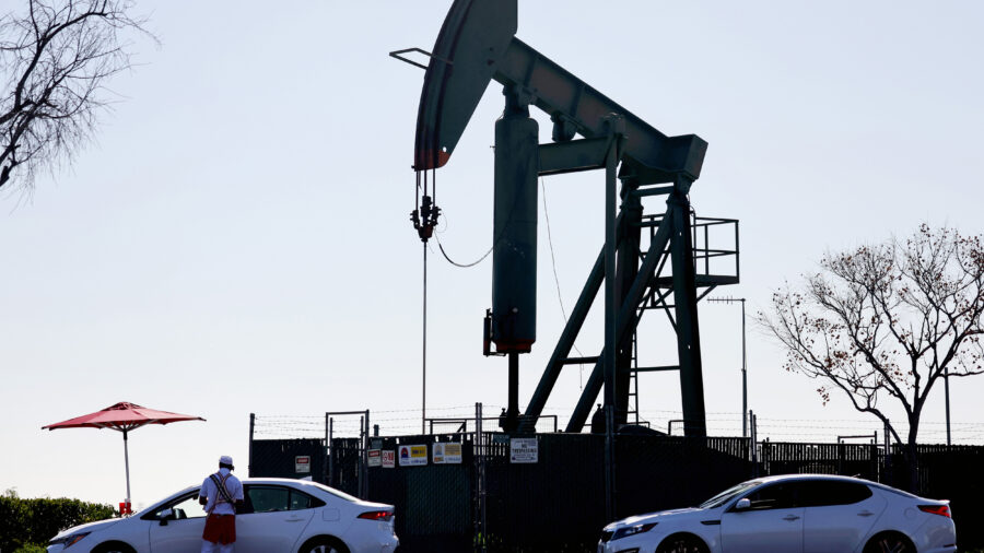 An oil pumpjack operates in the background as a fast food worker takes orders at a drive-through on Feb. 9, 2023, in Signal Hill, Calif. Credit: Mario Tama/Getty Images