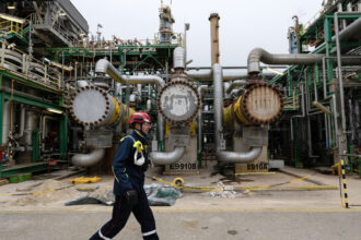 An employee walks on a platform at TotalEnergies’ La Mède refinery near Marseille, France. Credit: Miguel Medina/AFP via Getty Images