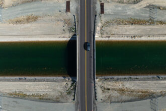 Cars drive over the Central Arizona Canal, which delivers Colorado River water to Central and Southern Arizona, on Dec. 19, 2025. Credit: Kayla Bartkowski/Los Angeles Times via Getty Images