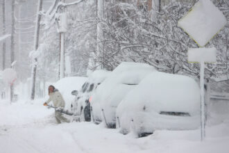 A person shovels out their car from a snow-covered street on Monday in Hoboken, N.J. Credit: Gary Hershorn/Getty Images