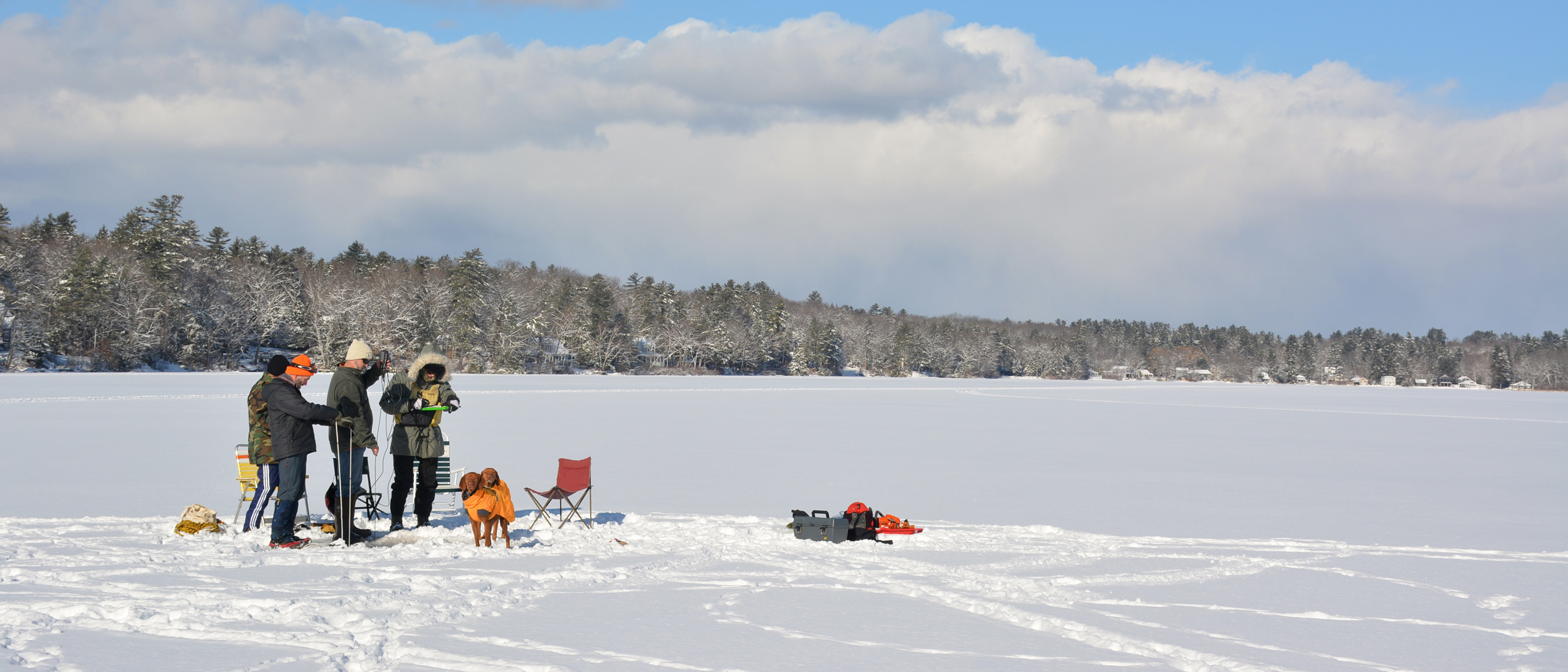 Lake Stewards of Maine members stand on a snow-covered Highland Lake in January 2026. Credit: Sydney Cromwell/Inside Climate News