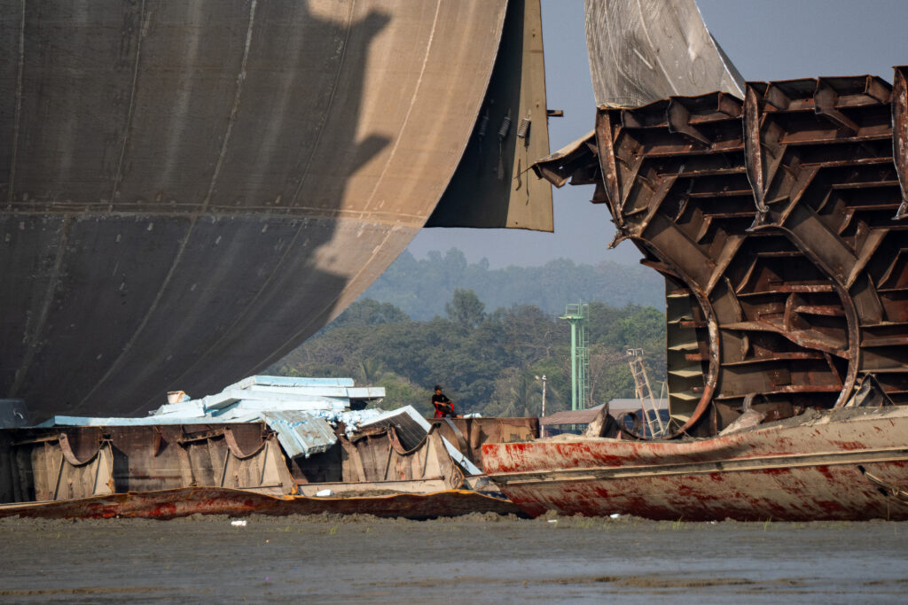 Among the debris, a worker rests on a chair in the Sitakunda ship graveyard. Credit: Spencer Call/NGO Shipbreaking Platform.