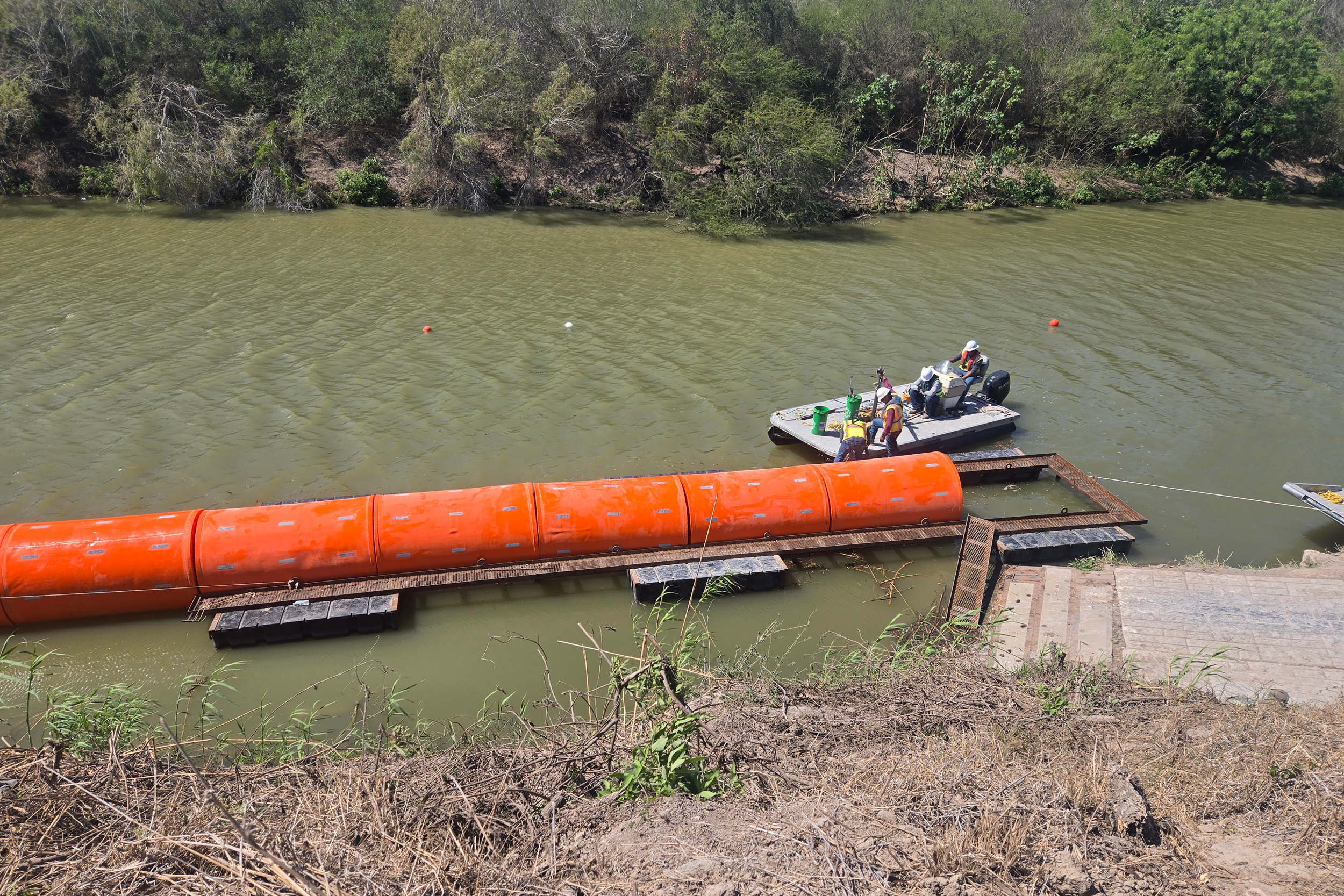 Contractors install buoys in the Rio Grande in Southmost Brownsville on Feb. 26. Credit: Courtesy of the South Texas Environmental Justice Network