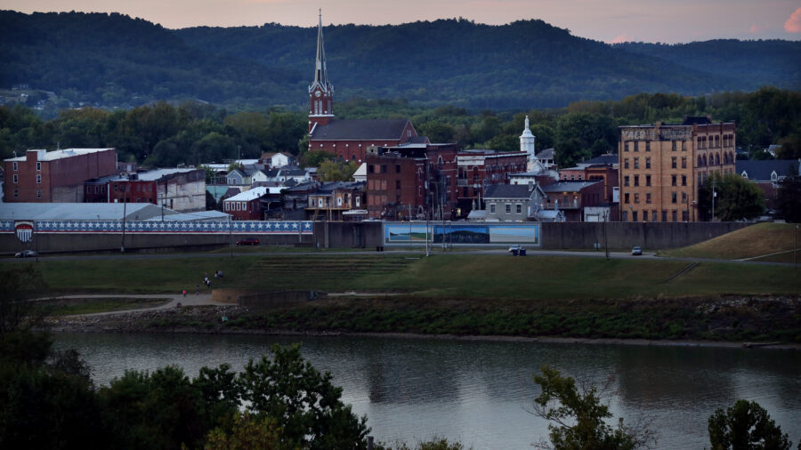 The view shows the river in the foreground, with the town and mountains behind.