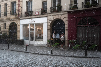 People take cover as a thunderstorm, accompanied by heavy hail, sweeps through Paris on May 3, 2025. Credit: Jerome Gilles/NurPhoto via Getty Images