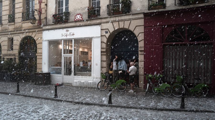 People take cover as a thunderstorm, accompanied by heavy hail, sweeps through Paris on May 3, 2025. Credit: Jerome Gilles/NurPhoto via Getty Images