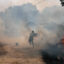 A man uses buckets of water to extinguish a wildfire that threatens his house in the Portuguese village of Antas on Aug. 15, 2025. Credit: Patricia de Melo Moreira/AFP via Getty Images