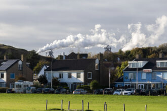 Homes and a hotel sit in front of a steel factory in Wijk aan Zee, Netherlands. Credit: Michel Porro/Getty Images